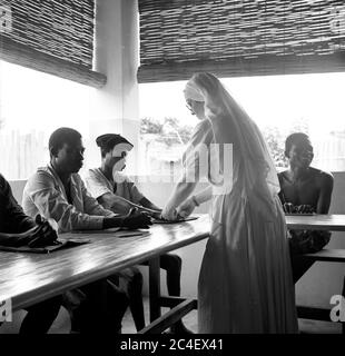 Nonne Missionary Kontrolle der Hände von jungen Männern in der Elfenbeinküste 1963 Elfenbeinküste 1960 Stockfoto