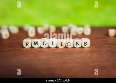 Nahaufnahme von isolierten Würfel auf einem Tisch, der das Wort Emotionen vor einem gesättigten Hintergrund zeigt Stockfoto