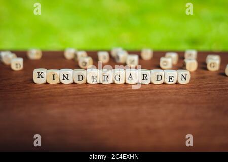 Nahaufnahme von isolierten Würfel auf einem Tisch, der das Wort Kindergarten vor einem gesättigten Hintergrund zeigt Stockfoto