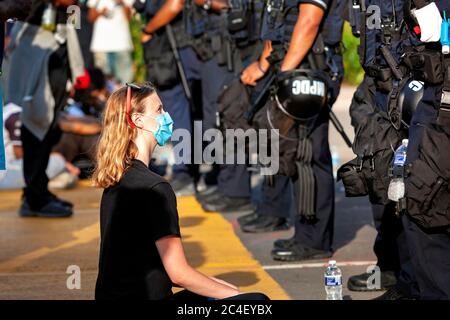 Der Protestierende sitzt vor der DC-Polizeilinie, die den Zugang zum Lafayette Park / Weißen Haus und der Statue von Andrew Jackson in Washington, DC, USA blockiert Stockfoto