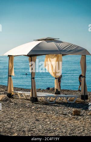 Weiße Strandvordächer bei Sonnenaufgang, am frühen Morgen. Luxus Strandzelte im luxuriösen Strandresort. Sommer Strand Konzept, Entspannung und Ruhe Design Stockfoto