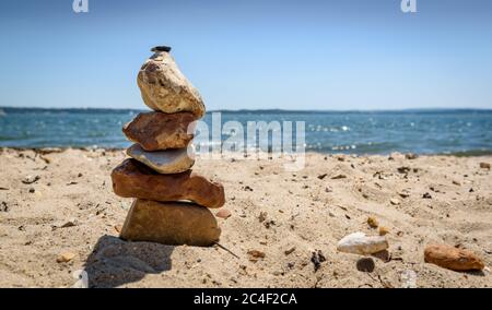 Einfacher Kiesstapel an einem Sandstrand Stockfoto