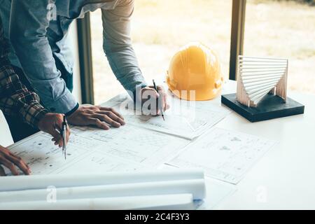 Zwei Techniker oder Kollegen, die an einem Projekt arbeiten und gemeinsam mit dem Blick auf die Papierkram diskutieren. Stockfoto