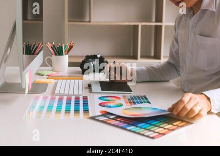 Freiberufliche kreative Designer arbeiten am Schreibtisch mit digitalem Grafiktablett und zeichnen mit Stift im modernen Home Office. Stockfoto