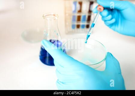 Wissenschaft tun Experiment im Labor Zugabe von Flüssigkeit in Reagenzglas mit Arbeit auf Aufgabe im Labor. Stockfoto