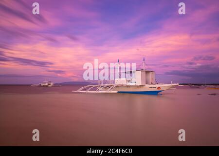 Traditionelle philippinische Bangka Boote am Strand bei Sonnenuntergang, Panglao, Philippinen Stockfoto