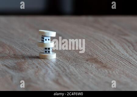 Zwei Plastikwürfel und Backgammon-Chips auf einem Tisch. Stockfoto