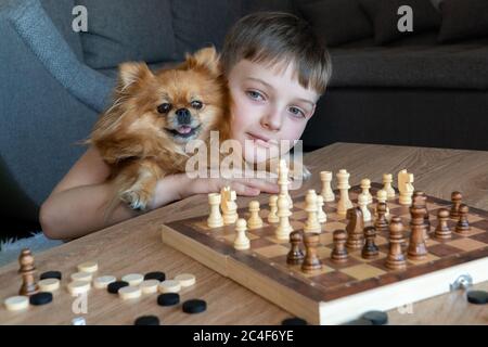 Fröhliches Kind spielt Schach. Ein lustiges Spiel mit Kindern im Schach Stockfoto