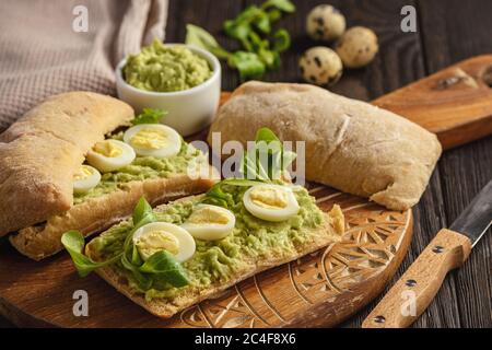 Avocado Sandwich Ciabatta mit Wachteleiern. Stockfoto