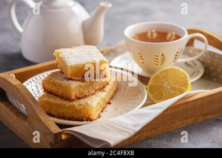 Hausgemachte Zitronenriegel und eine Tasse Tee. Stockfoto