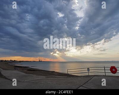 Sheerness, Kent, Großbritannien. Juni 2020. UK Wetter: Die grellenden Strahlen, die heute Abend in Sheerness durch Sturmwolken scheinen. Quelle: James Bell/Alamy Live News Stockfoto