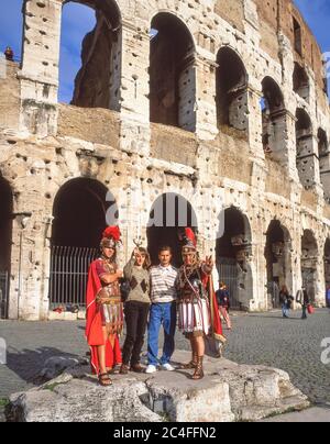 Römische Soldaten-Busker posieren mit Touristen-Paar vor dem Kolosseum (Colosseo), IV. Templum Pacis, Rom (Roma), Region Latium, Italien Stockfoto