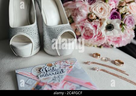 Hochzeit Braut Heels, Blumenstrauß, Karte gerade verheiratet und Gold Ohren und Ringe auf dem weißen Hintergrund. Vorbereitung der Braut Stockfoto