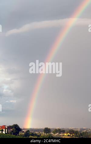 Farbenfroher Regenbogen an einem bewölkten Himmel. Nebliger Tag Stockfoto