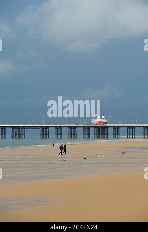 Paar zu Fuß Haustier Hund am Strand unter stürmischen Bedingungen, Blackpool, Großbritannien Stockfoto