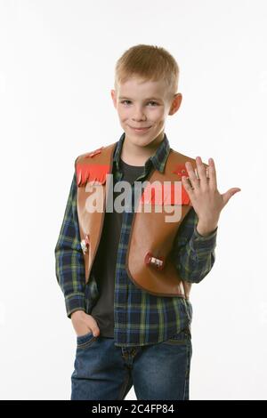 Porträt eines Jungen in einer Cowboys Weste und die Hand heben Stockfoto