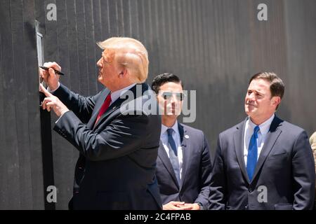 US-Präsident Donald Trump unterzeichnet als amtierender DHS-Sekretär Chad Wolf und Arizona Gov eine Gedenktafel an einem neuen Abschnitt der Grenzmauer entlang der mexikanisch-amerikanischen Grenze. Doug Ducey, rechts, schaut am 23. Juni 2020 in San Luis, Arizona. Stockfoto