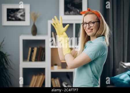 Frau trägt gelbe Gummihandschuhe während der Hausarbeit Stockfoto