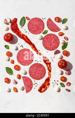 Flat Lay-Konzept für traditionelle italienische Pizzaauflagen aus frischen Zutaten, Gemüse, Gewürzen und Fleisch auf weißem Hintergrund Stockfoto