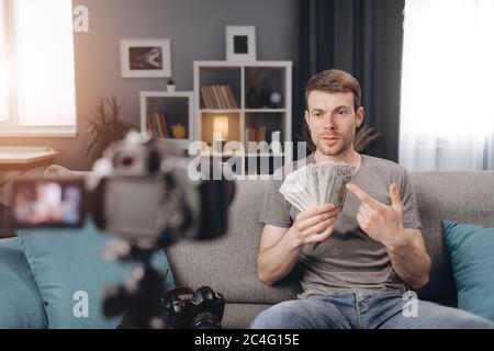Zuversichtlich männlichen Blogger Aufnahme online Tutorial über Geld Stockfoto