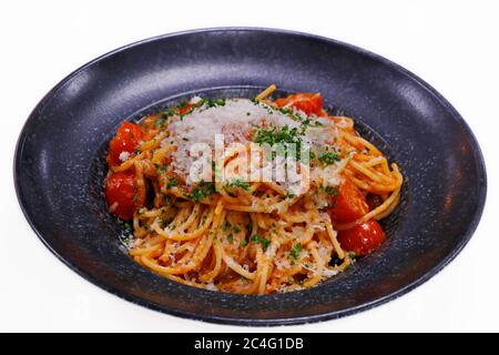 Spaghetti mit reicher cremiger Tomatensoße und geriebenem Parmeesankäse in einer Servierschüssel Stockfoto