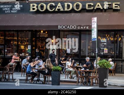 New York, USA. Juni 2020. Die Kellner tragen Gesichtsmasken, wenn sie zum ersten Mal Tische in der Lexington Avenue der Upper East Side servieren. Restaurants wurden autorisiert, Dienstleistungen im Freien zu öffnen, obwohl die Menschen noch verpflichtet sind, soziale Distanz zu beobachten, wie die Stadt in eine neue Phase der entspannten Beschränkungen durch den Ausbruch des Coronavirus gesetzt. Quelle: Enrique Shore/Alamy Live News Stockfoto