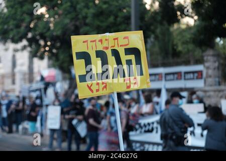 Jerusalem, ISRAEL 26. Juni 2020: Ein Demonstrator hält ein Schild mit der Aufschrift "Netanjahu der Dieb. Gantz' auch als Hunderte von Unterstützern der sogenannten Black Flag Anti-Korruptionsbewegung vor dem offiziellen Wohnsitz von Premierminister Benjamin Netanjahu demonstrieren, fordern er Rücktritt angesichts der Korruptionsanklagen gegen ihn in Jerusalem, Israel. Quelle: Eddie Gerald/Alamy Live News Stockfoto