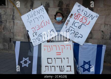 Jerusalem, ISRAEL 26. Juni 2020: Ein Demonstranten hält Plakate mit Kritik Zitaten, während Hunderte von Anhängern der sogenannten Black Flag Anti-Korruptions-Bewegung vor dem offiziellen Wohnsitz von Premierminister Benjamin Netanjahu demonstrierten und forderten, dass er angesichts der Korruptionsanklagen gegen ihn in Jerusalem, Israel, zurücktritt. Quelle: Eddie Gerald/Alamy Live News Stockfoto