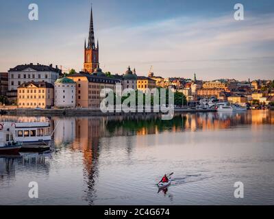 Stockholm, Schweden - 23. Jun 2020: Blick auf die Insel Riddarholmen und Sodermalm. Aktiver Kajakfahrer paddeln im Vordergrund Stockfoto