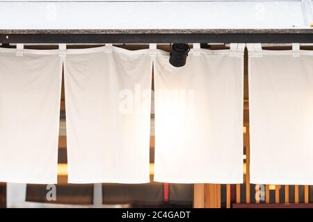 Der Vorhang-ähnliche Stoff, der vor traditionellen japanischen Restaurants und Geschäften hängt, dient nicht nur als Schild, sondern hat eine größere Bedeutung, Stockfoto