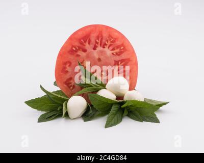 Weichkäse, Tomate und Minze auf weißem Hintergrund. Stockfoto