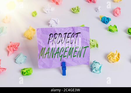 Word Writing Text Projektmanagement. Business Foto zeigt Praxis der Arbeit eines Teams, um bestimmte Ziele zu erreichen farbige zerknitterte Papiere leer Stockfoto