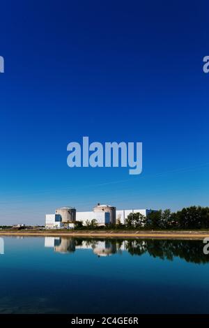 Fessenheim, Frankreich. Juni 2020. Die beiden Reaktorgebäude des Kernkraftwerks Fessenheim (AKW) spiegeln sich in der Wasseroberfläche des Rheinseitenkanals. Mit dem Abschalten des zweiten Reaktors wird das umstrittene Kraftwerk an der Grenze zu Deutschland endgültig stillgelegt. Der erste Reaktor war bereits Ende Februar vom Netz gegangen. Quelle: Philipp von Ditfurth/dpa/Alamy Live News Stockfoto