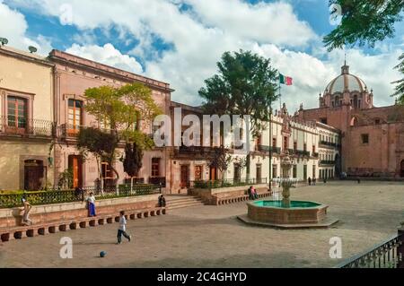 Zacatecas, Mexiko - 23. Oktober 2006: Palast des Gouverneurs mit der mexikanischen Flagge und Kathedrale unserer Lieben Frau von der Himmelfahrt. Junge Jungs spielen so Stockfoto