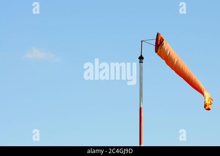 Eine Orange Windsack oder Windvane gegen den blauen Himmel Stockfoto