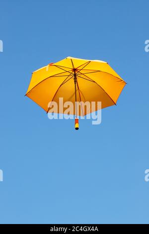 Blick auf einen orangefarbenen Schirm in niedriger Winkel vor einem klaren blauen Himmel. Stockfoto