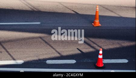 Orangefarbene Reflexkegel auf einer Straße, als eine Maßnahme zur Verkehrsberuhigung verwendet. Stockfoto