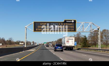 Social Distanzing Information Schild über einer Autobahn in der Nähe von London, ON - Zeichen gefördert von der Regierung von Ontario. Stockfoto