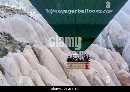 Passagiere an Bord eines Heißluftballons genießen eine Fahrt am frühen Morgen durch die Landschaft rund um das Dorf Goreme in der Türkei. Stockfoto