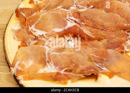 Parmaschinken (Prosciutto di Parma) auf einem Holzbrett präsentiert. Der Schinken wird rund um die Stadt Parma in Norditalien hergestellt. Stockfoto