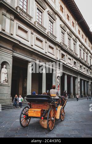 Eine touristische Kutsche, die an den Uffizien vorbeiführt, einem Kunstmuseum an der Piazza della Signoria im historischen Zentrum von Florenz, Italien Stockfoto