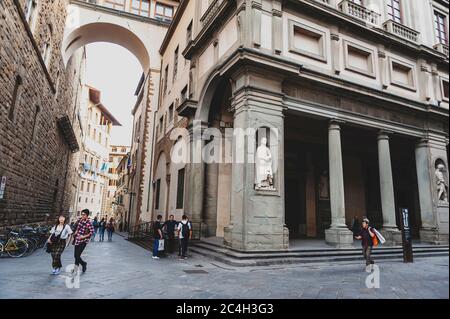 Touristen, die an den Uffizien vorbei gehen, einem Kunstmuseum, das sich neben der Piazza della Signoria im historischen Zentrum von Florenz, Italien, befindet Stockfoto