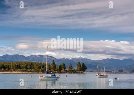 Mapua, Tasman, Bay Coast, South Island, Neuseeland. Segelboote auf der Waimea Mündung mit Blick auf Rabbit Island und Berghintergrund. Stockfoto