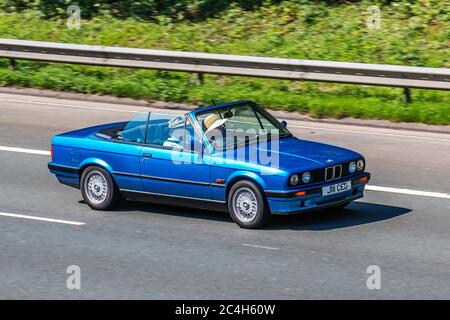 1992 90er Jahre blau BMW 318 i Cabriolet; Vehicular Traffic Moving Vehicles, Autos, die Fahrzeuge auf britischen Straßen fahren, Motoren der 90er Jahre, Autofahren auf dem Autobahnnetz M6. Stockfoto