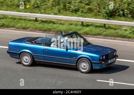 1992 90er Jahre blau BMW 318 i Cabriolet; Vehicular Traffic Moving Vehicles, Autos, die Fahrzeuge auf britischen Straßen fahren, Motoren der 90er Jahre, Autofahren auf dem Autobahnnetz M6. Stockfoto