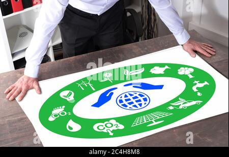 Mann, der ein Umweltschutzkonzept beobachtet, das auf einem Schreibtisch platziert wird Stockfoto