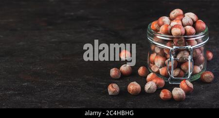 Haselnüsse in einem Glas auf dunklem Grund Stockfoto