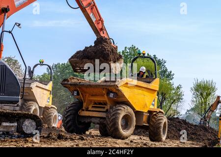 Bagger lädt Erde in Kippwagen auf der Baustelle Stockfoto