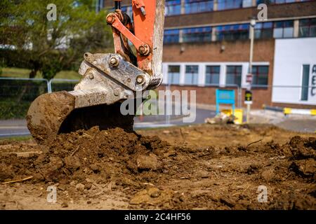 Baggerschaufel bewegt die Erde auf der Baustelle Stockfoto