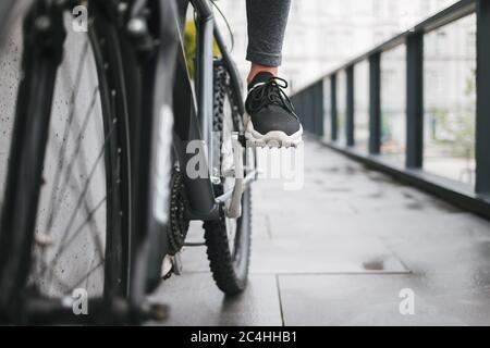 Mädchenfuß auf dem Fahrradpedal. Frau fährt eine Stadt auf dem Fahrrad Stockfoto